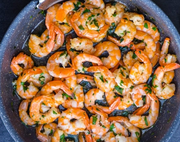 Pan of sautéed shrimp with garlic and herbs.